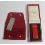 A Cased Cartier Pentagon Red and Gold Boxed Lighter and Cartier solid silver lighter. Both A/F