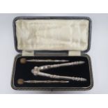 A Cased Set of Electroplated Silver Nut Crackers with a pair of nut picks with carved faux walnut