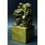 A Chinese Bronze Seal decorated with foo dog and with inset coral and turquoise, 12cm high