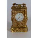 An Ornate Gilt Cased Miniature Carriage Clock decorated with caryatids, 8.5cm. Running with key