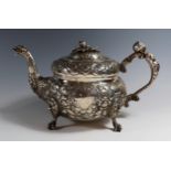 A George III Irish Silver Teapot with heavily embossed decoration, mask and bird's head spout,