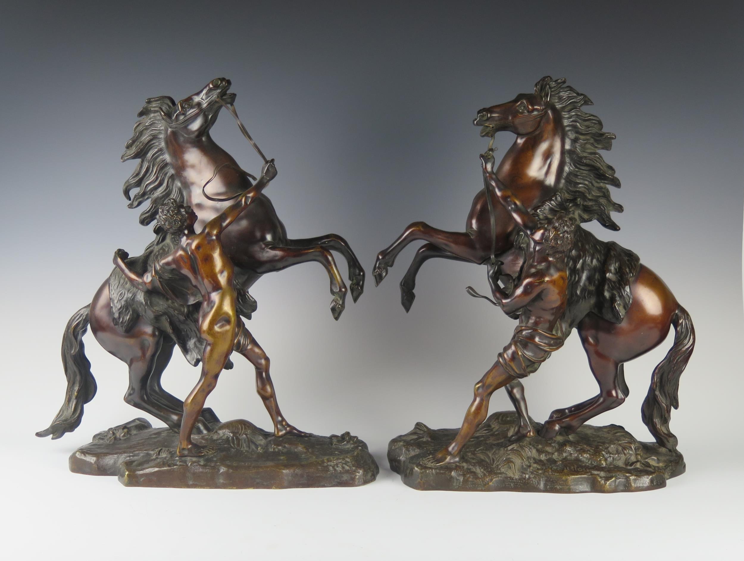 A Pair of French Bronze Marly Horses, bases signed Coustou, 45 cm high, bases 33.5 cm