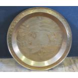 An Embossed Brass Charger decorated with foliage and fish (89cm diameter)