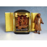 A Japanese Lacquered 'Altar'. the twin hinged doors opening to reveal a figural icon (93mm high) and