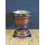 A 19th Century Elm Based and Ebonised Wine Cooler with swing handled brass bucket liner, 36cm diam.