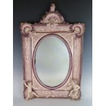 A 19th Century Continental Maiolica Framed Wall Mirror decorated with putti, shells, mask, bull