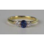 A Moderrn 18ct Yellow Gold, Sapphire and Diamond Trilogy Ring, the pricipal 5 x 4mm stone flanked by