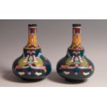 A pair of late 19th Century Longwy French Faience ware bottle vases, with Persian enameled