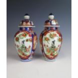 A pair of 20th Century Imari vases and cover, 25cm high, (4).