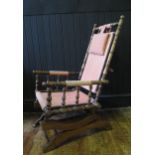 A late Victorian American rocking chair, set on safety rocker, with headrest and loose cushion.