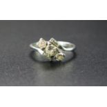 Three Stone Diamond Crossover Ring in a platinum setting flanked by two rectangular cut diamonds