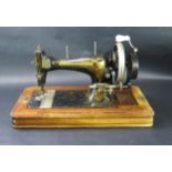 A Frister and Rossman hand crank, sewing machine, circa 1914, in a walnut veneer case, Tunbridge