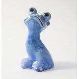 An Arts and Crafts pottery ugly figure, of seated cat/ frog with glass eyes, dark blue C.H.