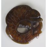 A Chinese hardstone Bi disc in the fo9rm of a lizard, possibly brown jade, 5.5cm diameter.