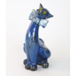 C.. H. Brannam Barum, seated cat with yellow inset eyes, dark blue, green and black glaze, incised