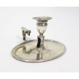 A George III silver chamberstick, of oval form, reeded decoration, engraved crest and initials,