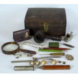 A hardwood box containing four pencils, a trench art paperknife, a penknife, a magnifier glass, a