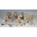 A collection of nine German porcelain pincushion half dolls, together with two Hummel figures and