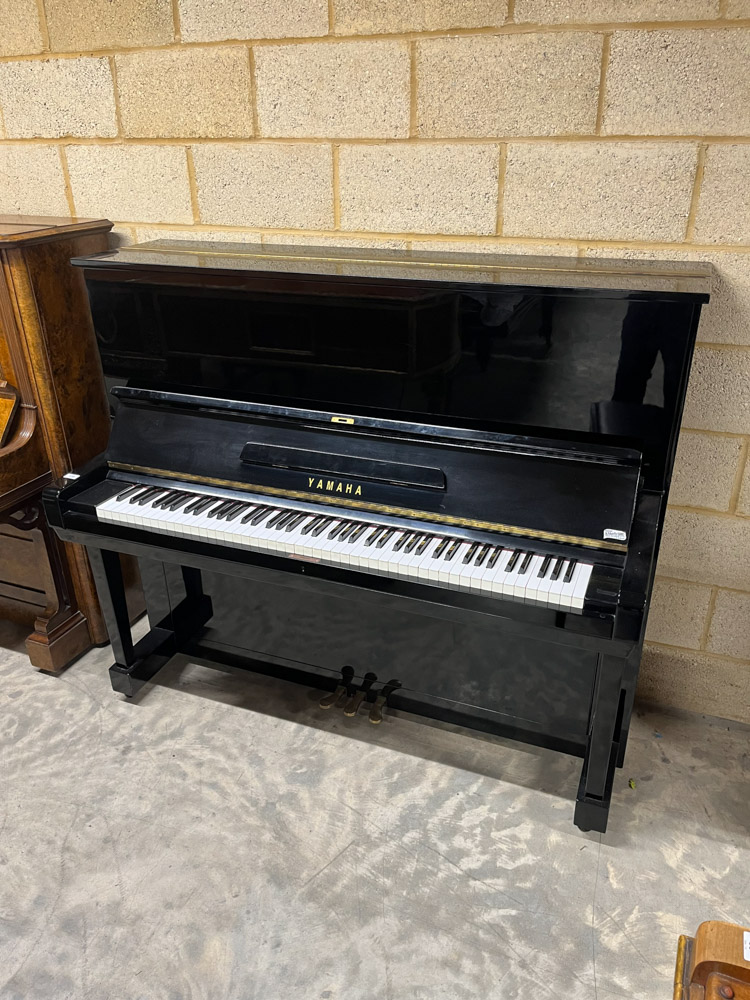 Yamaha (c1961) A Model U3 upright piano in a traditional bright ebonised case; together with a