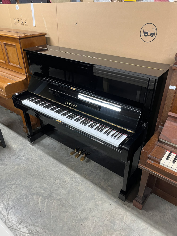 Yamaha (c1974) A Model U1 upright piano in a bright ebonised case; together with a matching stool.