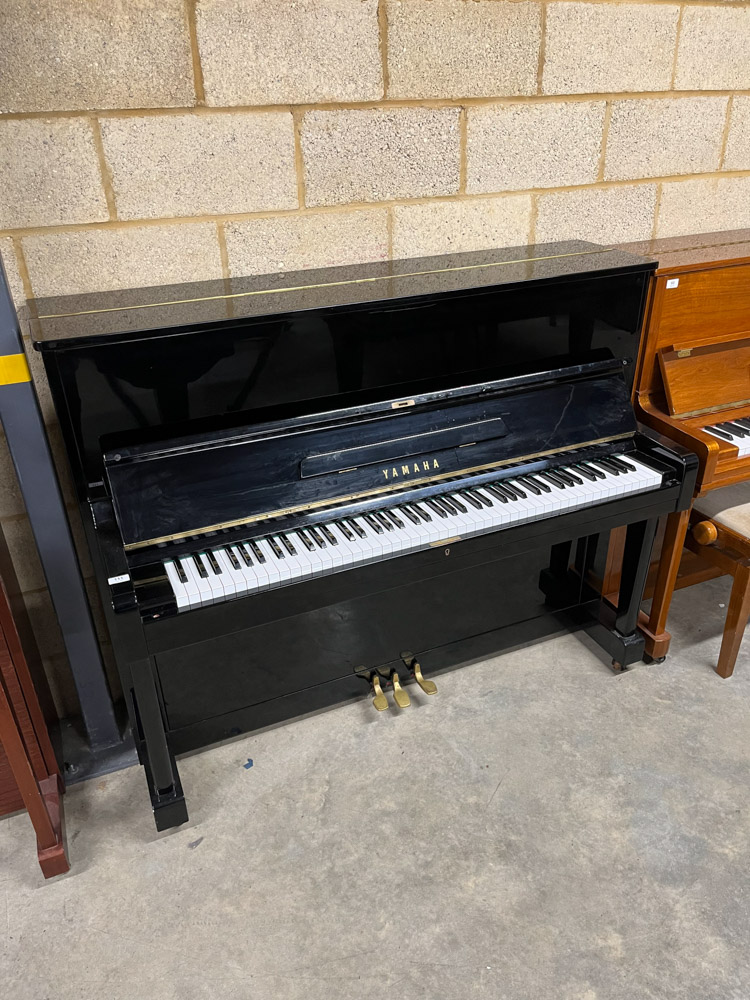 Yamaha (c1961) A Model U1E upright piano in a traditional bright ebonised case; together with an