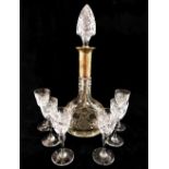 A set of six cut glass liqueur glasses and a matching decanter with silver collar,