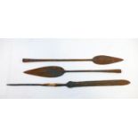 Three African iron spear heads, the longest 50cm, and a carved tribal wooden ceremonial paddle,