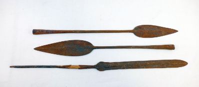 Three African iron spear heads, the longest 50cm, and a carved tribal wooden ceremonial paddle,