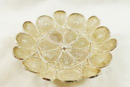 An Indonesian silver coloured metal circular flower head filigree dish, raised on three feet, 10.