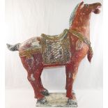 A Tang style red painted wooden horse, on rectangular plinth,