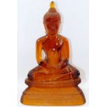 An amber glass seated Buddha,