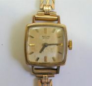 A 9 carat gold ladies Record bracelet watch, the cushion-shaped face with baton numerals, 14.