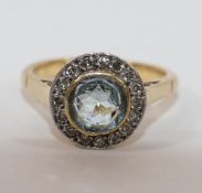 A yellow metal aquamarine and diamond circular cluster ring,