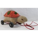 A 1950's Merrythought stuffed red and green felt and beige velvet pull along tortoise on red