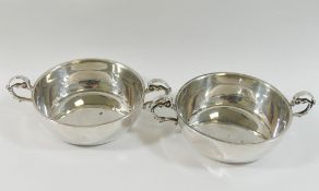 A pair of modern silver two-handled wine tasters, of plain form with scroll handles,