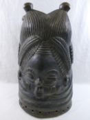 An African Mende carved helmet mask from Sierra Leone, carved with two faces (front and back),