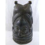 An African Mende carved helmet mask from Sierra Leone, carved with two faces (front and back),