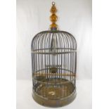 A brass bird cage, with turned wooden surmount, with wooden perch, swing,