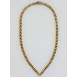 A yellow metal herringbone hollow link necklace, terminating in a point, stamped '9K', 28.