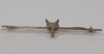 A bi-colour bar brooch centrally mounted with a diamond set foxes head, with red gem-set eyes, 6.