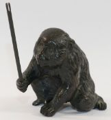 A Japanese Meiji period bronze of a macaque monkey, holding aloft a stick, signed to base of foot,