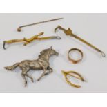 A child's yellow metal buckle ring stamped '9CT' and a yellow metal wishbone brooch,