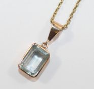 An aquamarine pendant, the emerald cut aquamarine in open back rub-over setting stamped '375',