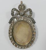 A large 19th century paste set silver locket, with hinged back and bow surmount, 7.5cm long x 4.