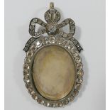 A large 19th century paste set silver locket, with hinged back and bow surmount, 7.5cm long x 4.