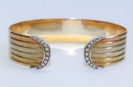 An Italian tri-colour gold cuff bracelet with diamond set terminals, stamped '750', 16mm wide, 33.