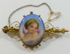 A Victorian gold bar brooch, set with oval hand painted porcelain plaque decorated with a cherub,