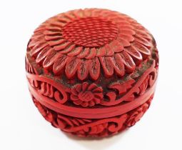 A small Cinnabar red lacquer circular box, the top carved with a flower head,