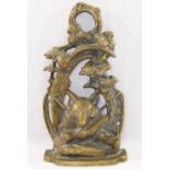 A 20th century brass door stop, cast with a fox mask and hunting regaila within a scroll surround,