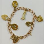 A yellow metal curb link charm bracelet, with 9 carat gold heart-shaped padlock clasp, London 1980,